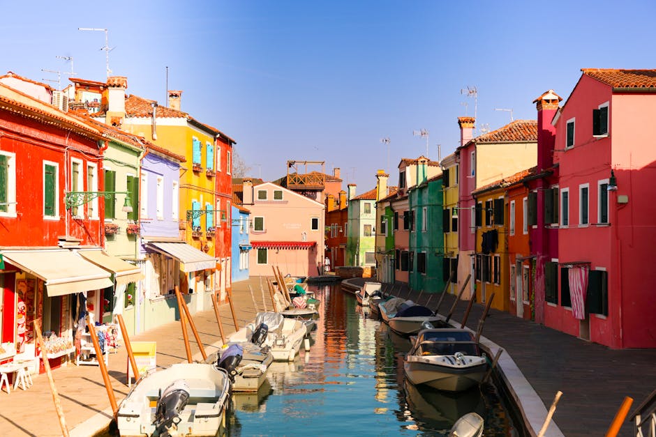 A picturesque view of Burano's colorful houses lining a serene canal, showcasing the vibrant charm of Italian architecture.